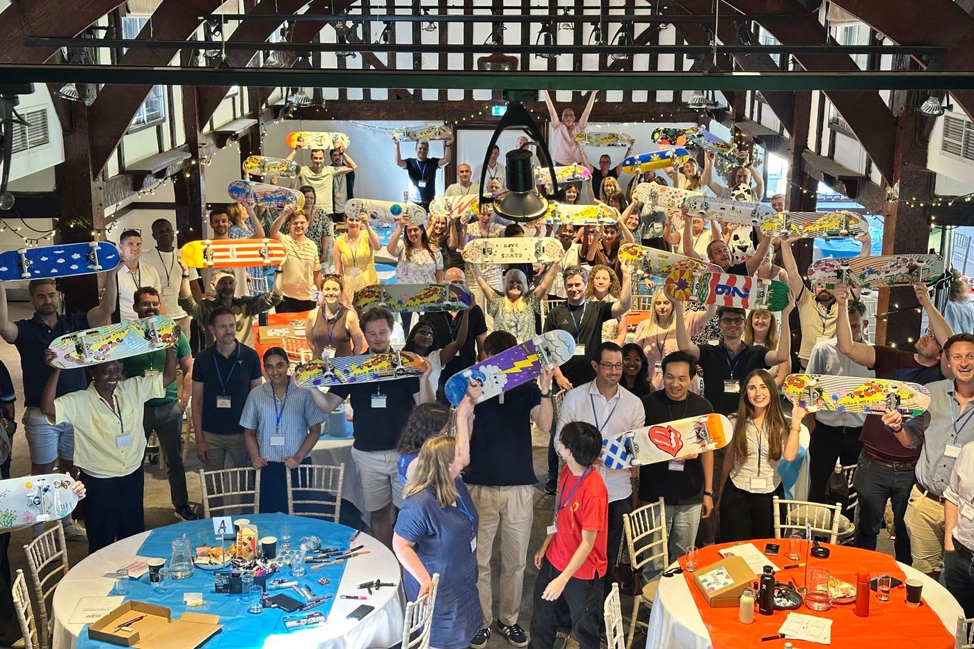 A hall of people holding up the skateboards they decorated