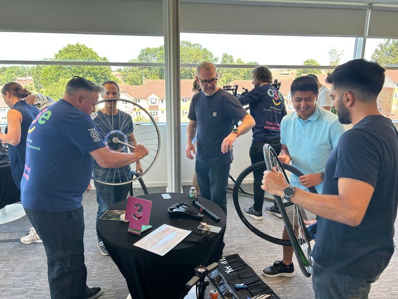 A team fitting wheels at a charity bike build in a hotel function room