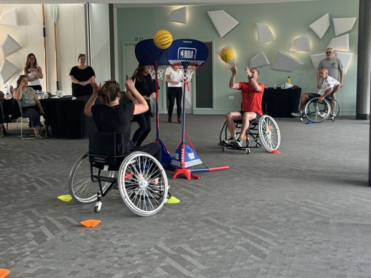 People playing basketball in the sports wheelchairs a team built