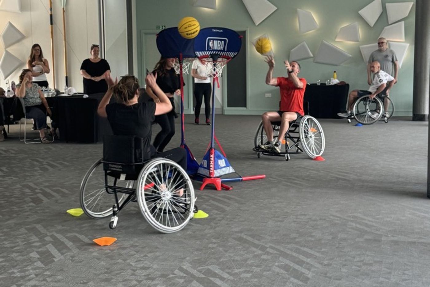 People playing basketball in the sports wheelchairs a team built