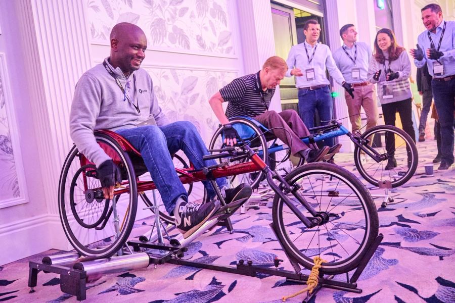 Two people competing in Racing Wheelchairs to win Ozone to help build a Sports Wheelchair