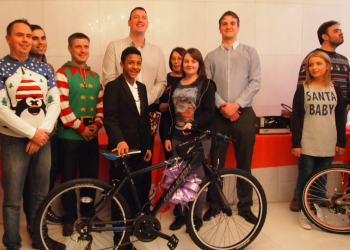 A picture showing a team handing over a bike for christmas