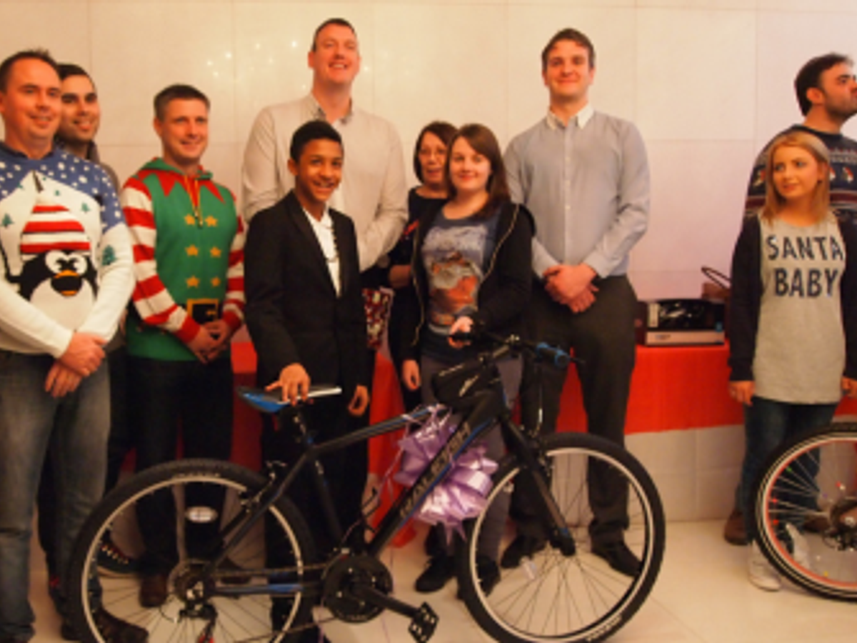 A picture showing a team handing over a bike for christmas