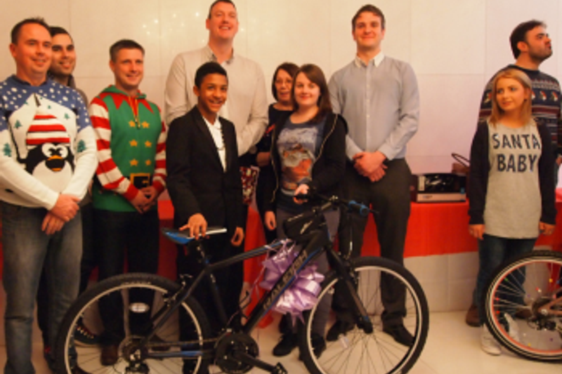 A picture showing a team handing over a bike for christmas