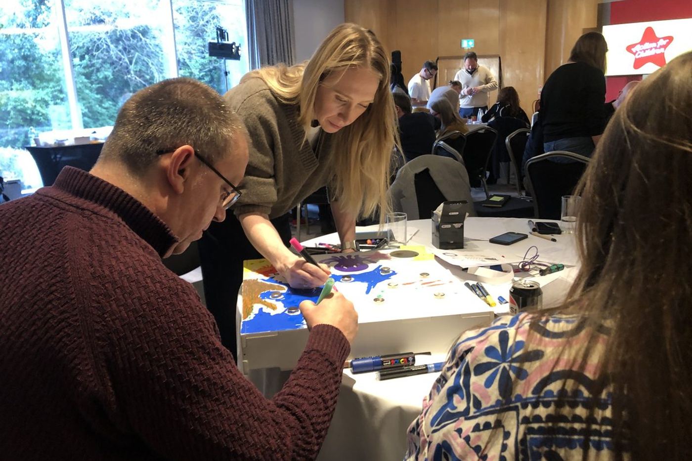 A team building at tables during a short session at a conference