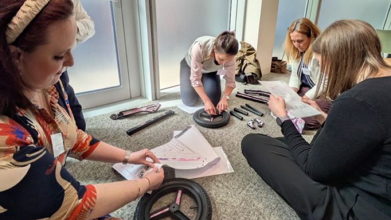 Charity team building in Manchester: a team building a children's scooter against the clock