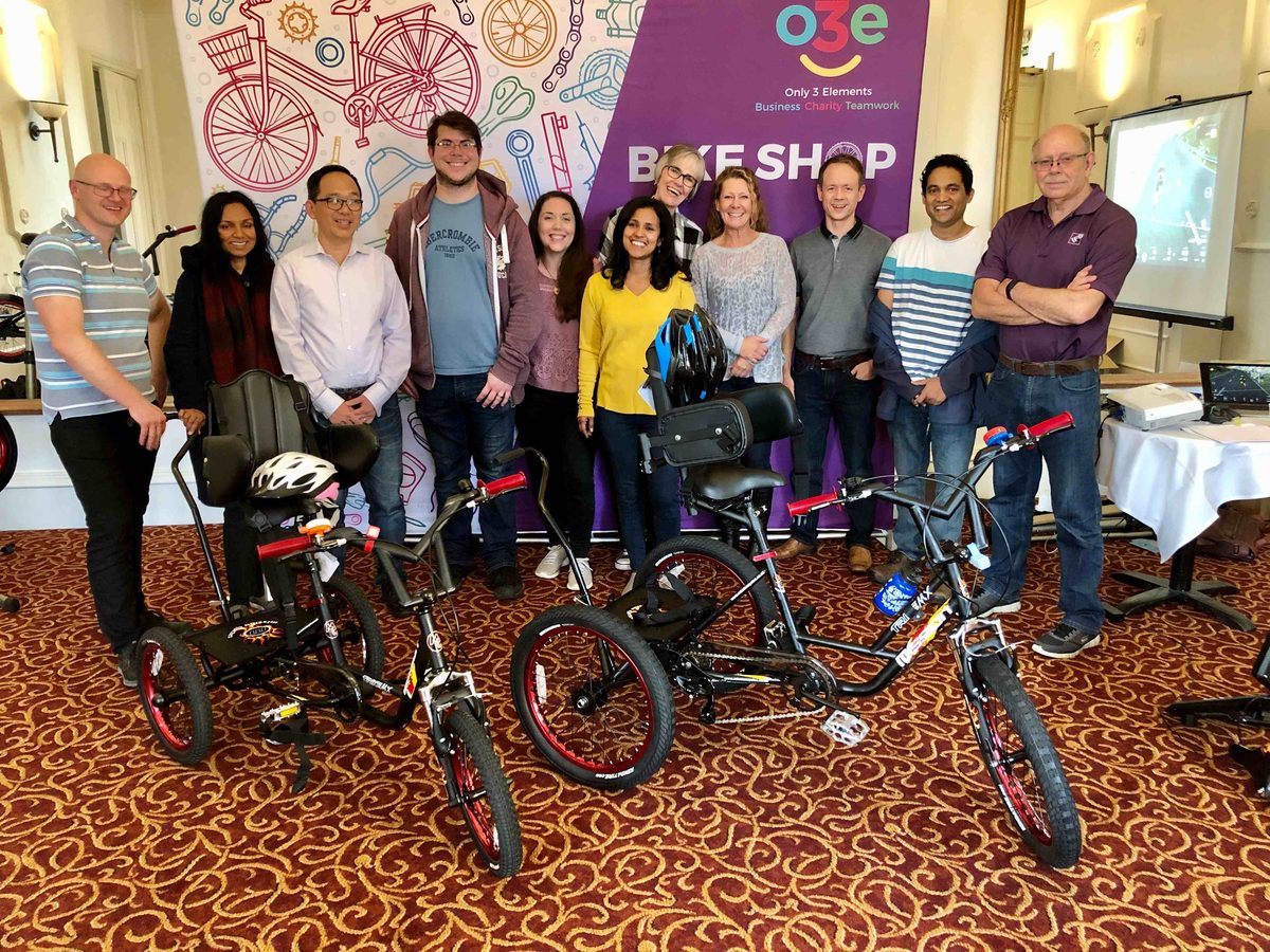 A team standing behind the trikes they built and donated