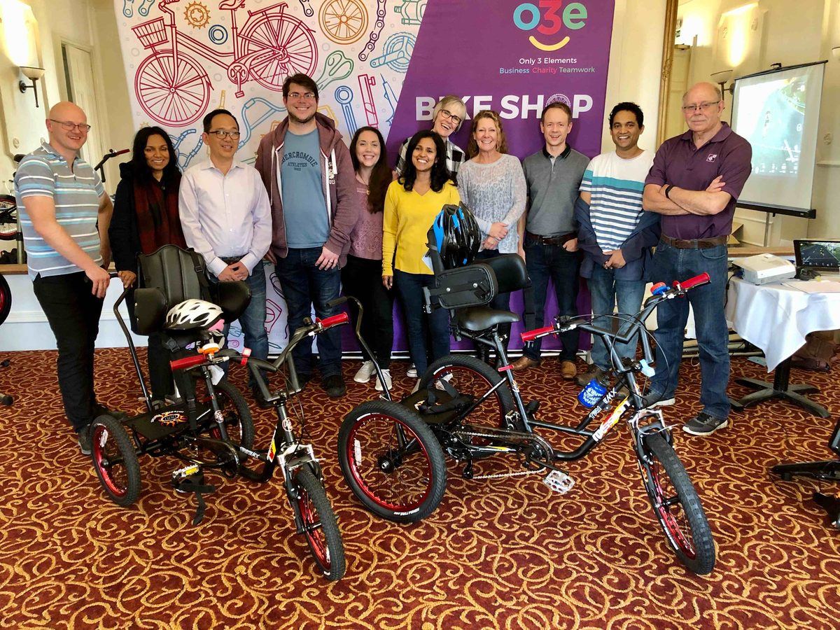 A team standing behind the trikes they built and donated
