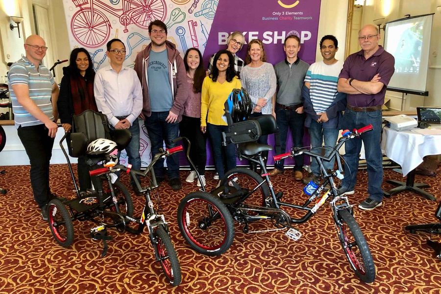 A team standing behind the trikes they built and donated