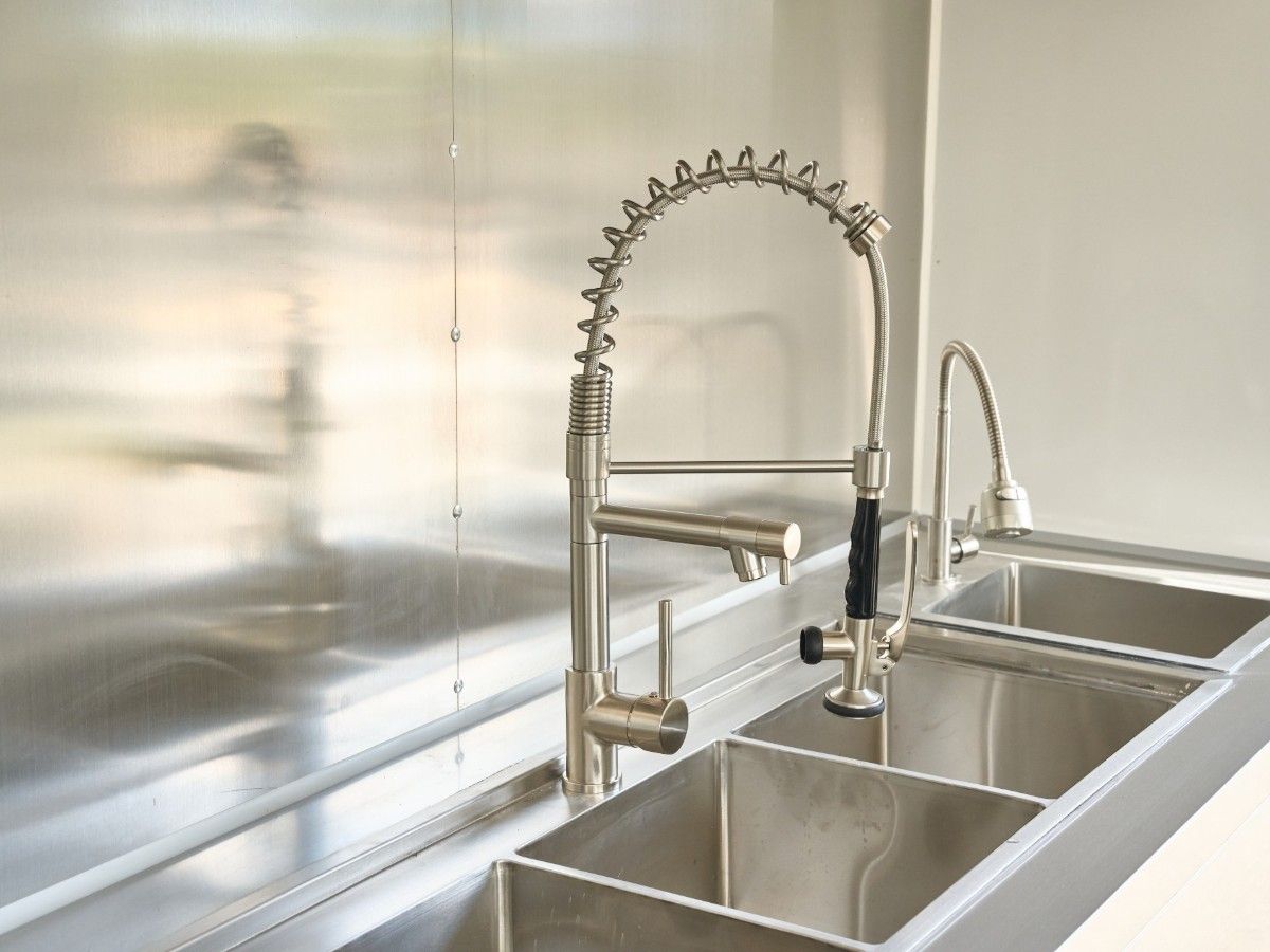 Commercial 3 compartment stainless steel sink with pull down sprayer in a Chris Machinery trailer