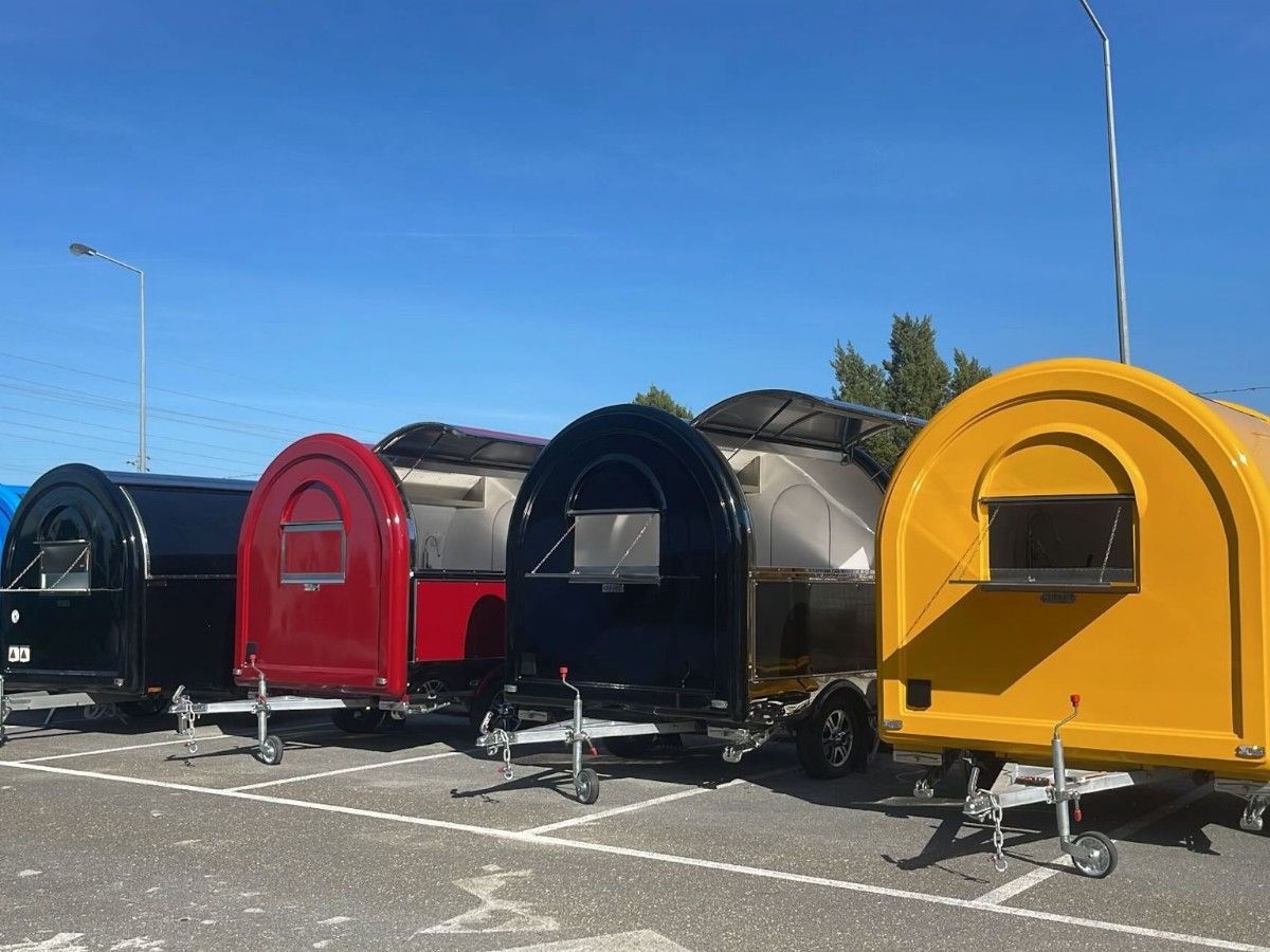 Multiple colorful Chris Machinery concession trailers parked in line at customer venue