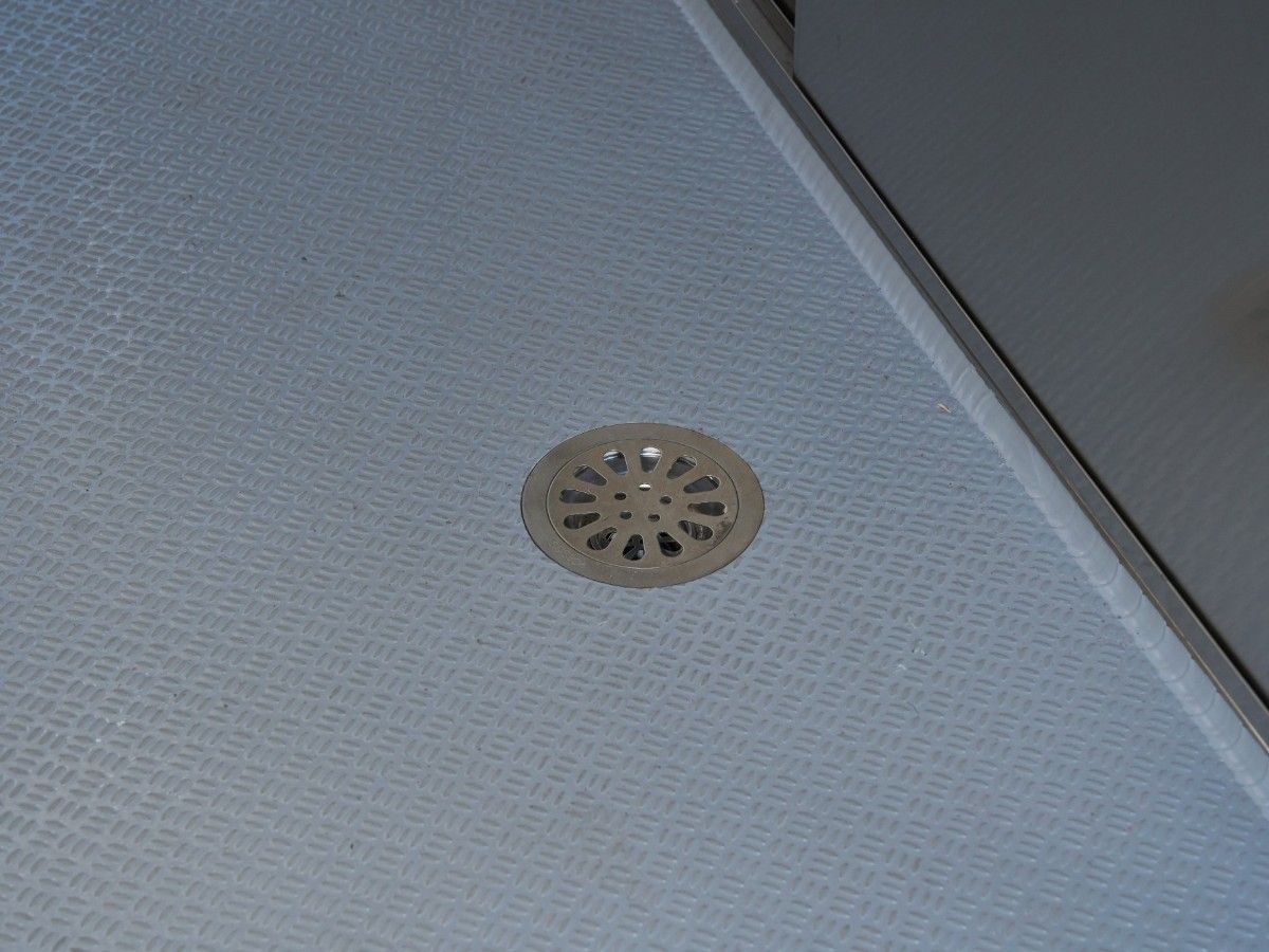 Stainless steel floor drain plate installed in a Chris Machinery mobile food trailer