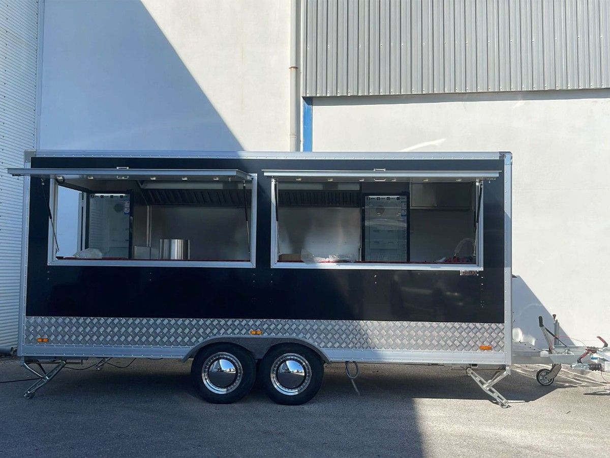 Chris Machinery black food trailer operating outdoors with open service window