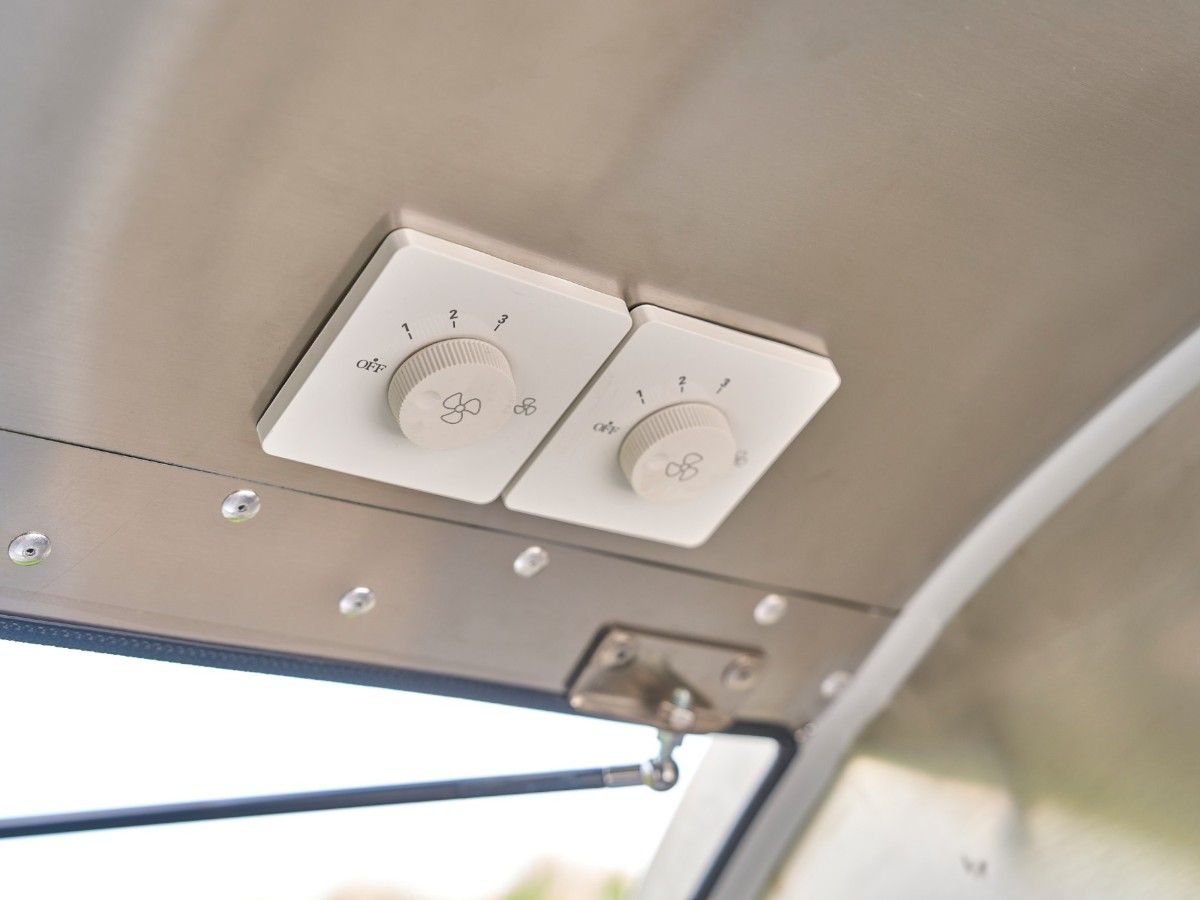Wall mounted fan and light control switches inside a Chris Machinery food trailer interior