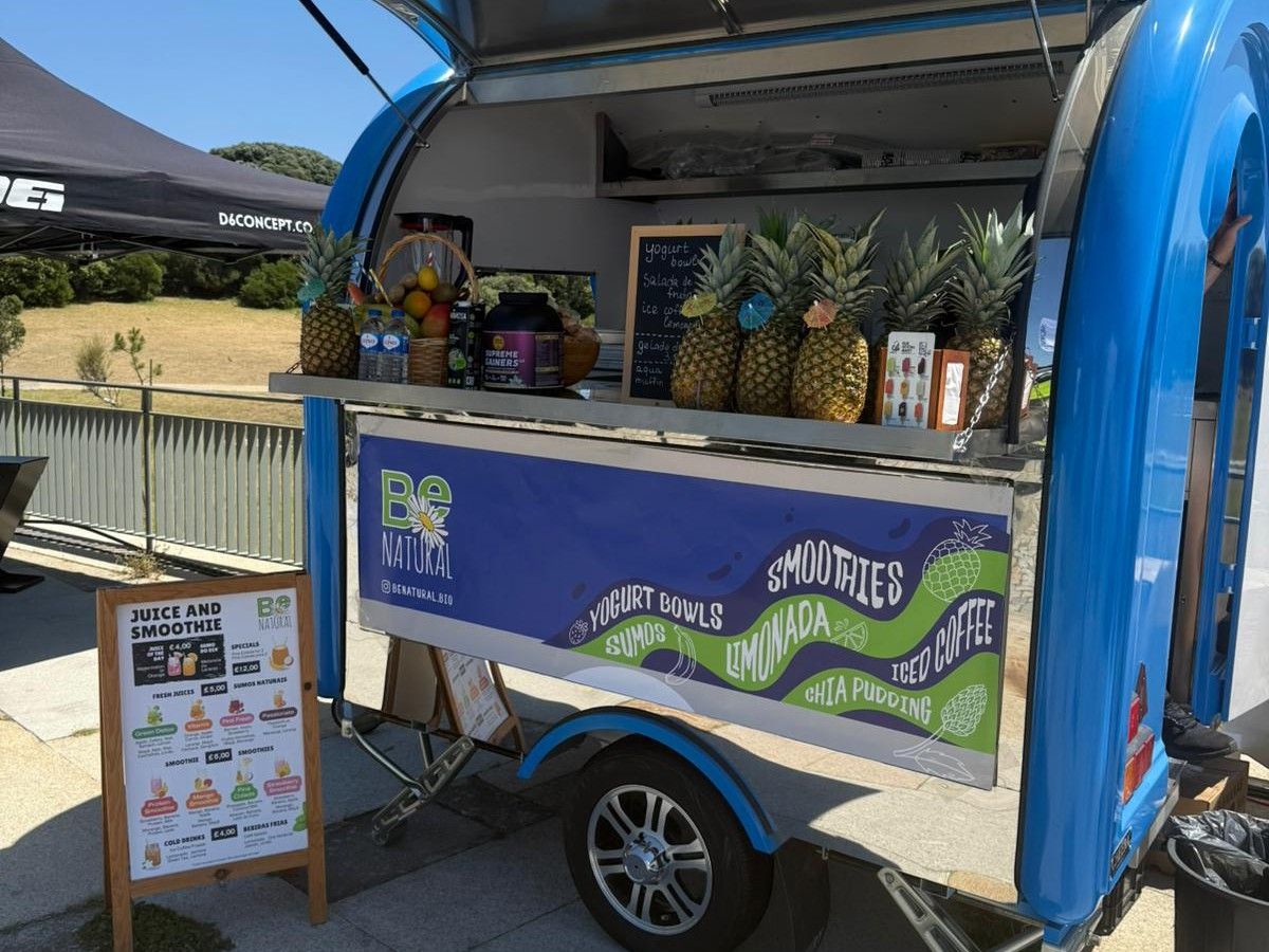 Blue Chris Machinery mobile bar trailer operating under sunny outdoor tent setup