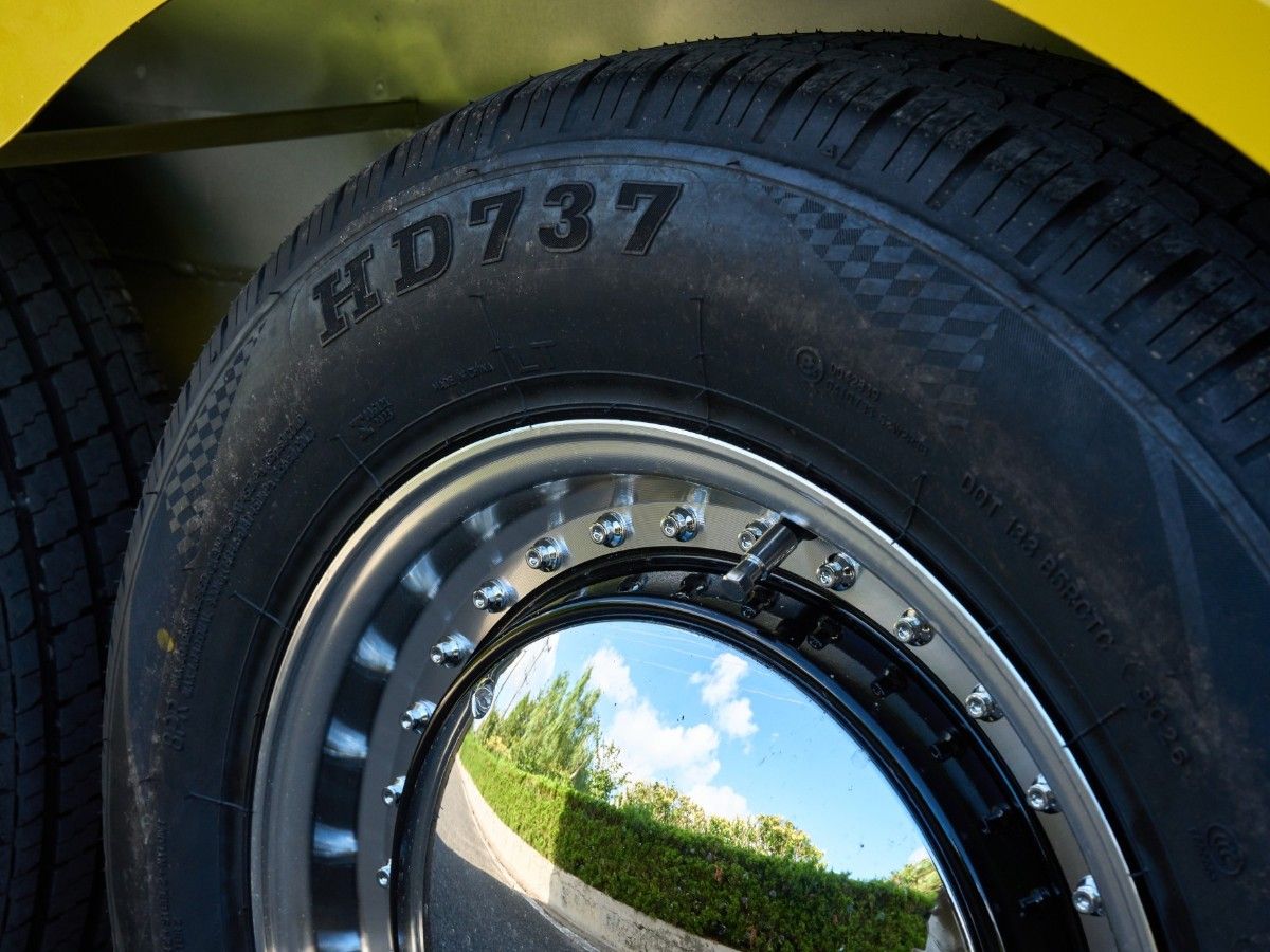Heavy duty road tire with shiny chrome rim fitted on a Chris Machinery food trailer