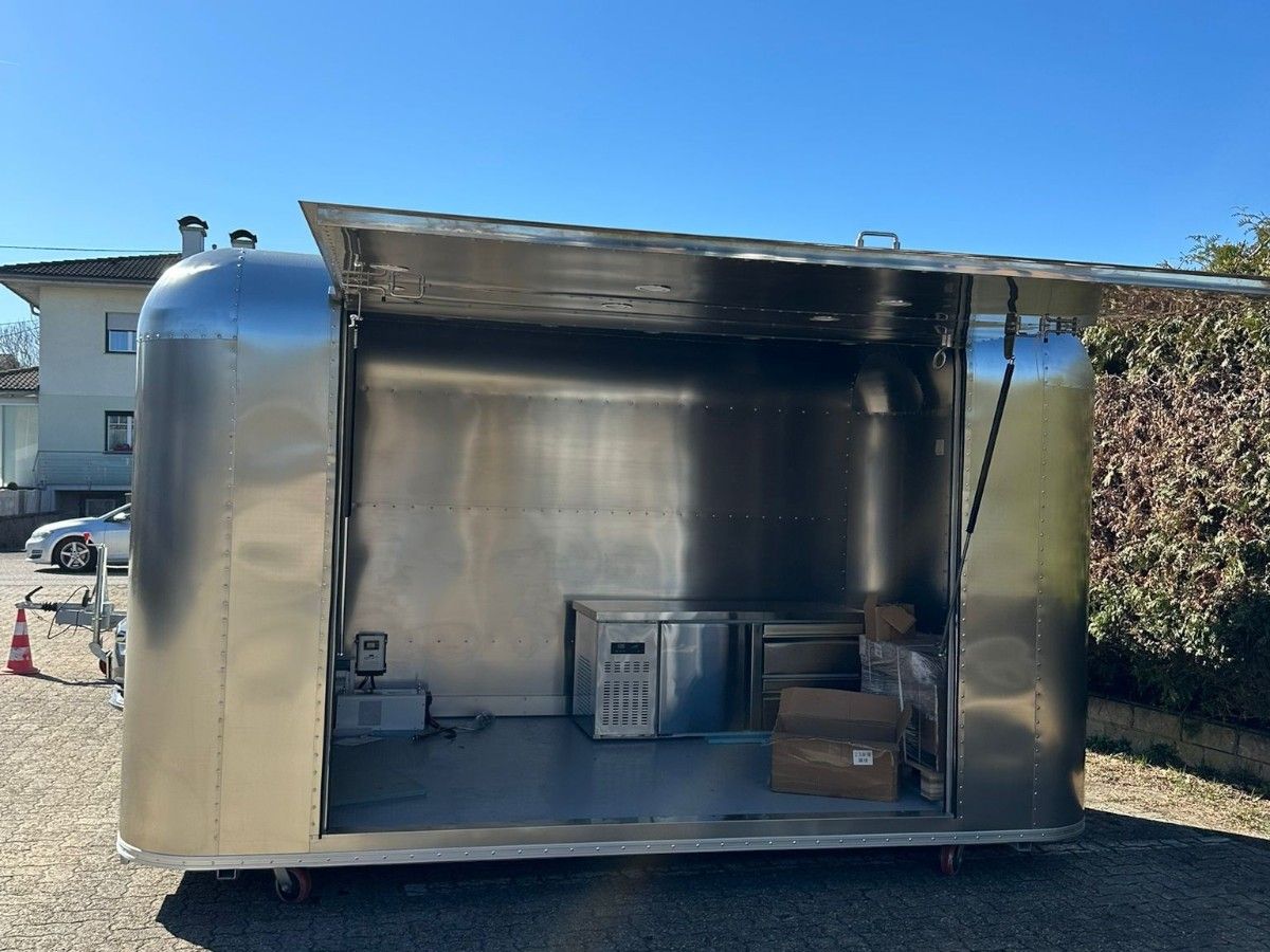 Customer operating a Chris Machinery stainless steel concession trailer with hatch open