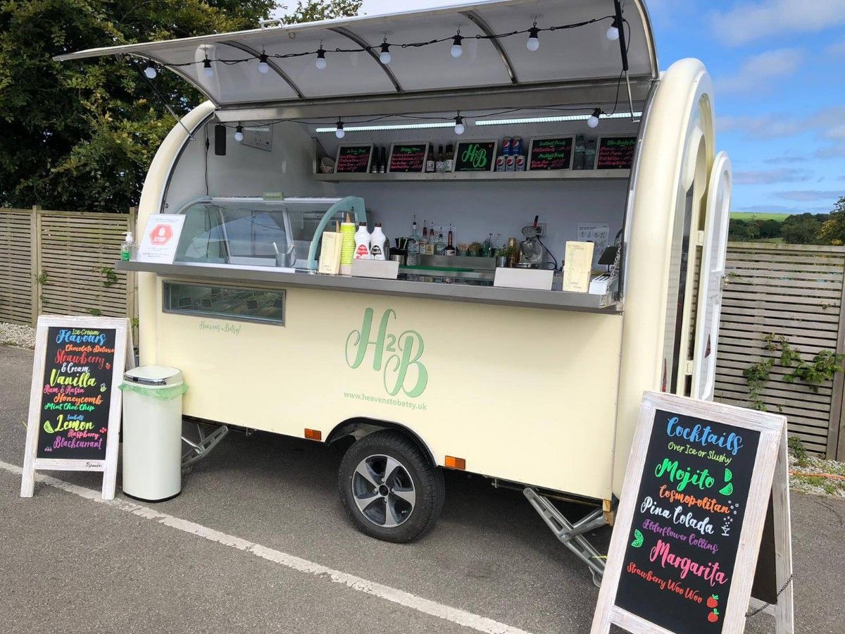 Chris Machinery beige mobile coffee shop trailer operating outdoors with menu boards