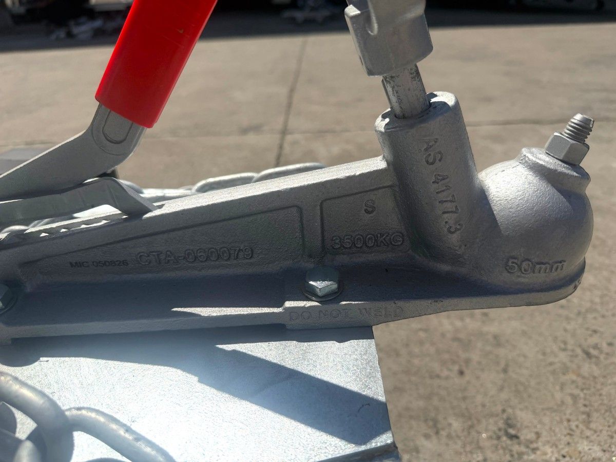 Tow hitch ball coupler with hand brake lever on a Chris Machinery mobile food trailer