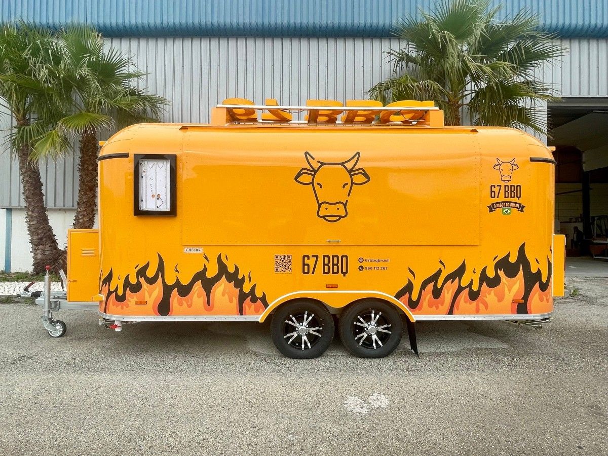 Customer bright yellow food trailer with flame graphics built by Chris Machinery