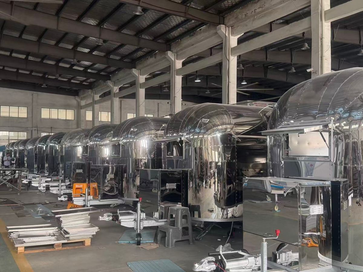 Open production floor at Chris Machinery showing welding and assembly of custom food trailers