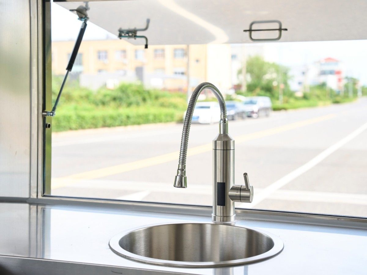 Commercial goose neck water faucet and stainless steel sink inside a Chris Machinery food trailer