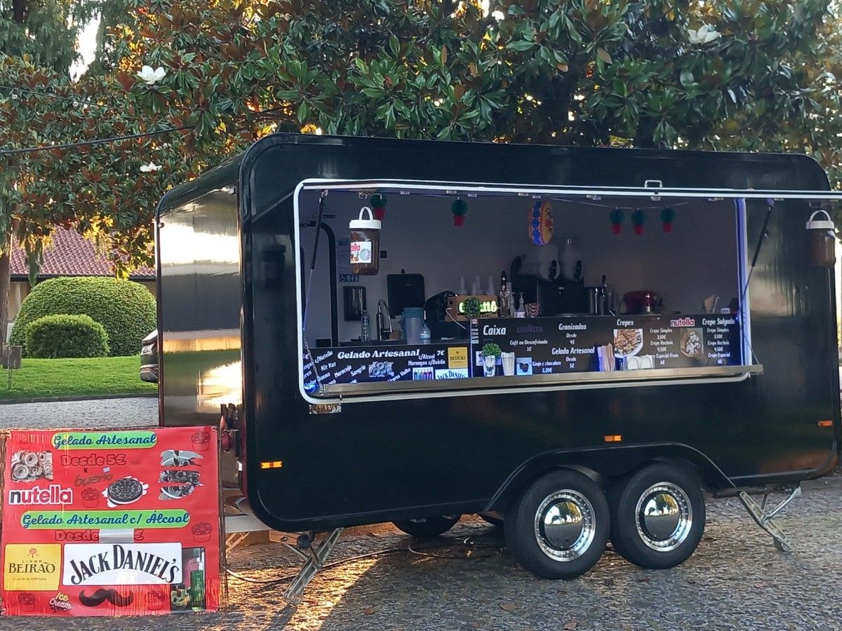 Black Chris Machinery mobile catering trailer operating with warm interior lighting at night