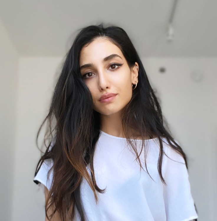 portrait of a woman with long black hair, wearing a white shirt.