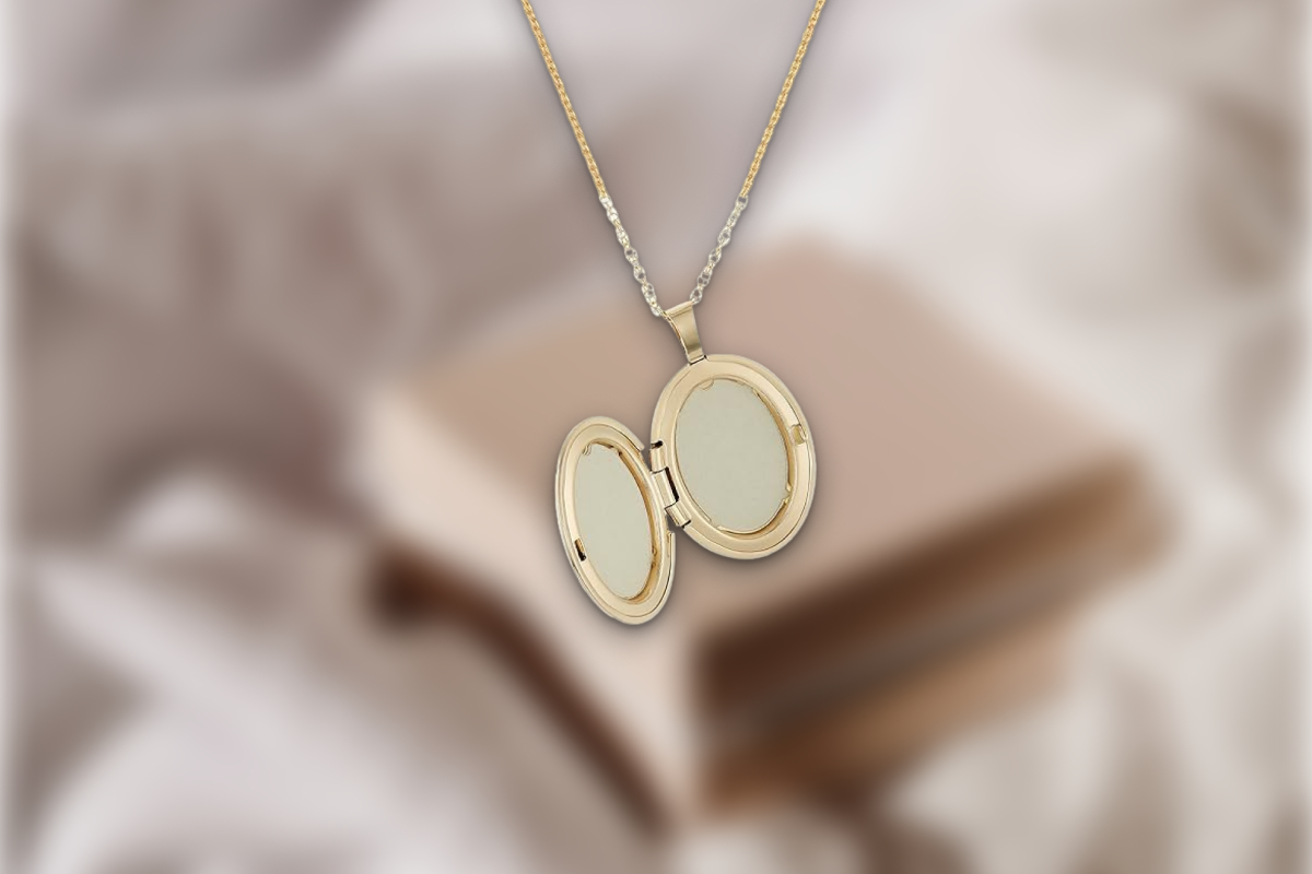 A timeless, polished sterling silver classic locket pendant necklace resting on a soft silk fabric.
