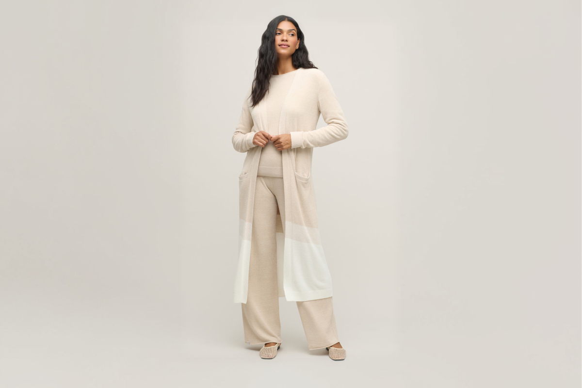 chic loungewear that feels like a continuous, warm hug all day.	A woman wearing a cozy, soft knit Barefoot Dreams CozyChic UltraLite cardigan in a neutral taupe color.