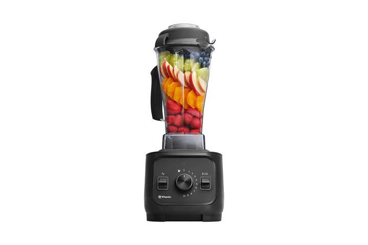 A powerful black Vitamix Explorian blender filled with a vibrant, freshly blended green wellness smoothie.