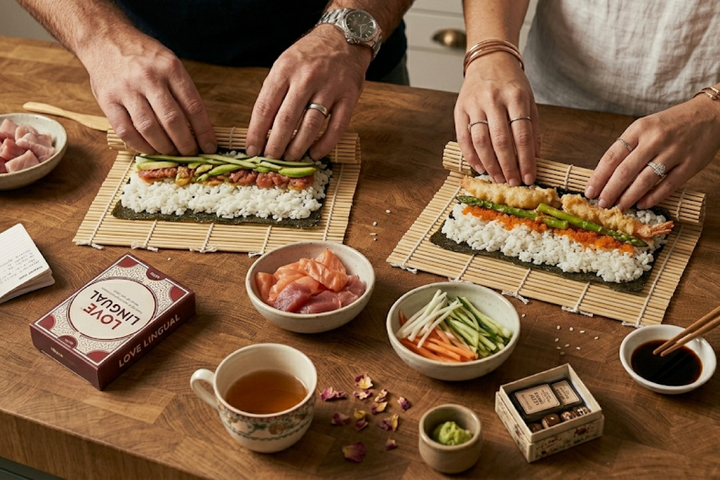 A DIY sushi rolling kit on a kitchen counter with fresh tuna, avocado, nori sheets, and a bamboo mat.