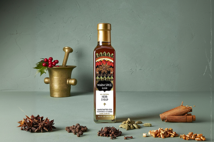 glass bottle containing artisanal cocktail syrups and botanical bitters infusion droppers, arranged elegantly with spices in a product setting