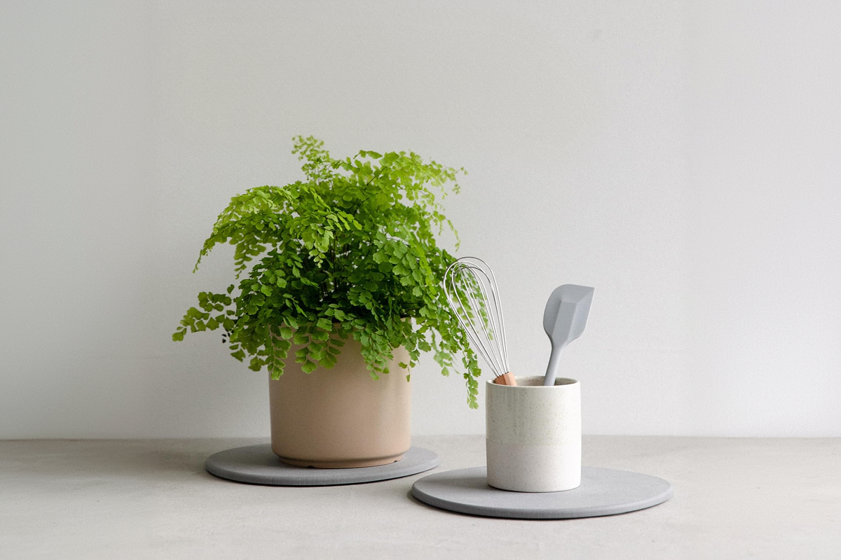 A gray tray with delicately placed cup and pot ontop.