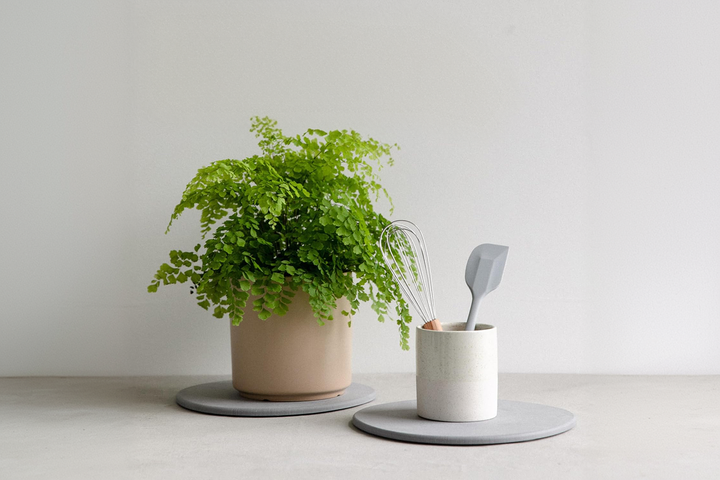 A gray tray with delicately placed cup and pot ontop.