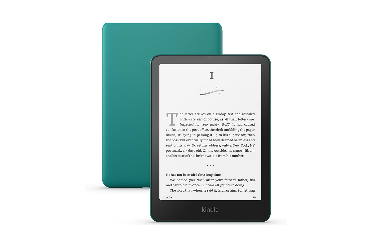 An open Amazon Kindle Paperwhite displaying a book page next to a peaceful, warm cup of tea.