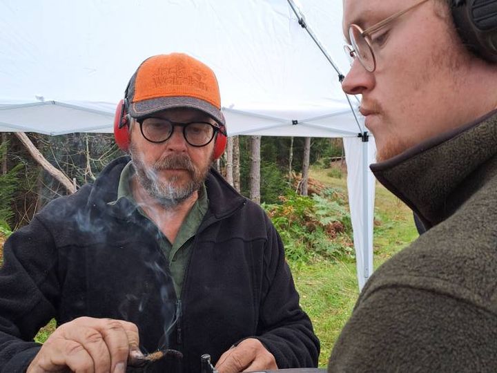 Kursdeltagare med antika vapen samlade utomhus.