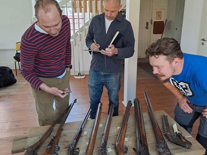 Deltagare övar historiskt skytte vid ett tält på skjutbanan.