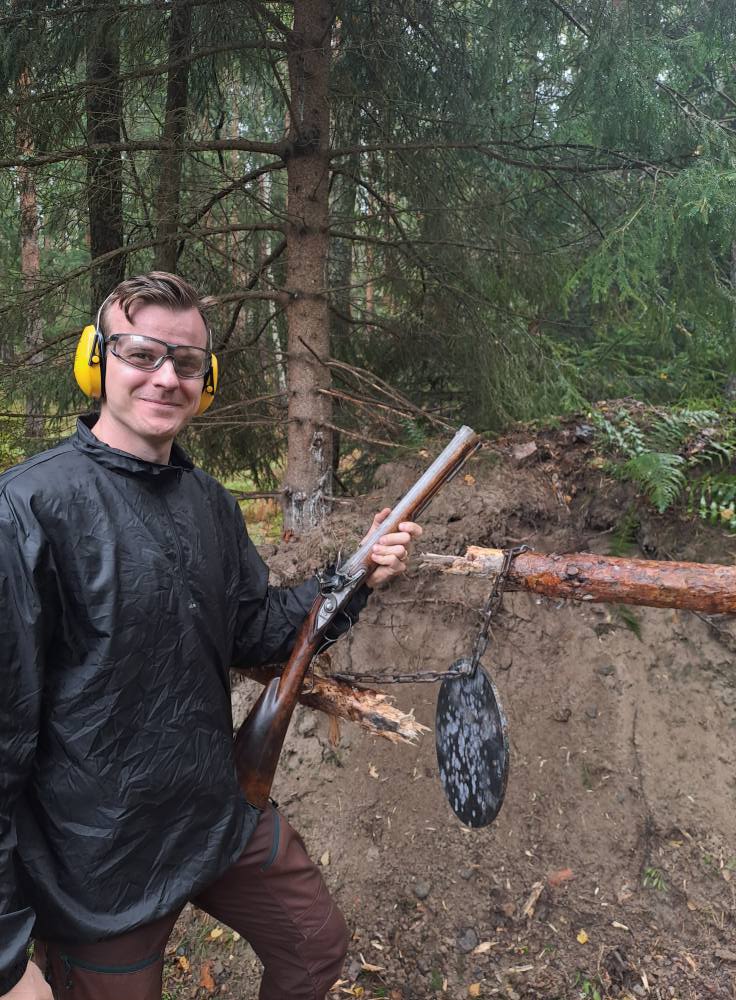 Gruppbild från kurs i historiskt skytte med deltagare och antika vapen.