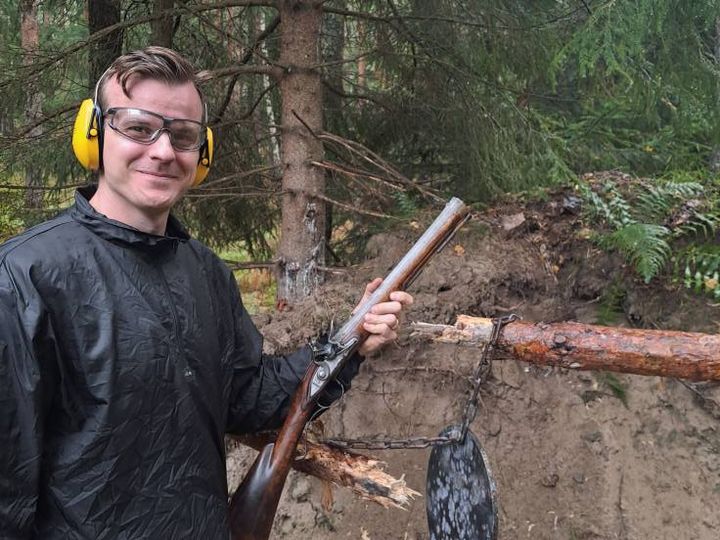 Gruppbild från kurs i historiskt skytte med deltagare och antika vapen.