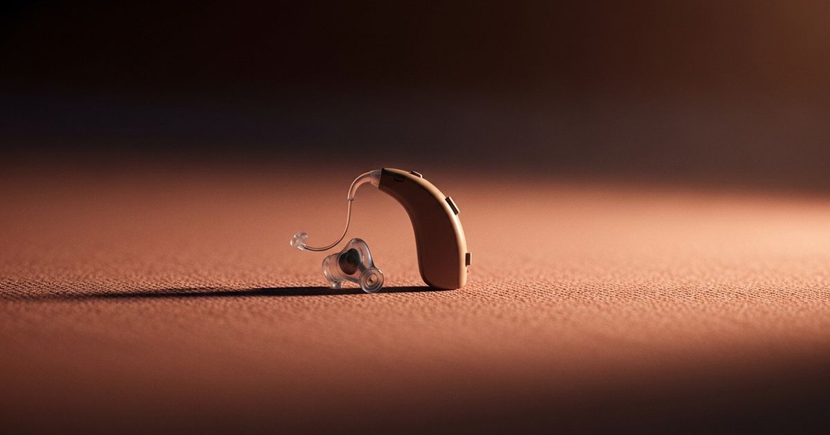 Close-up, hyper-realistic image of a modern hearing aid on warm fabric conveying professional, approachable hearing care.