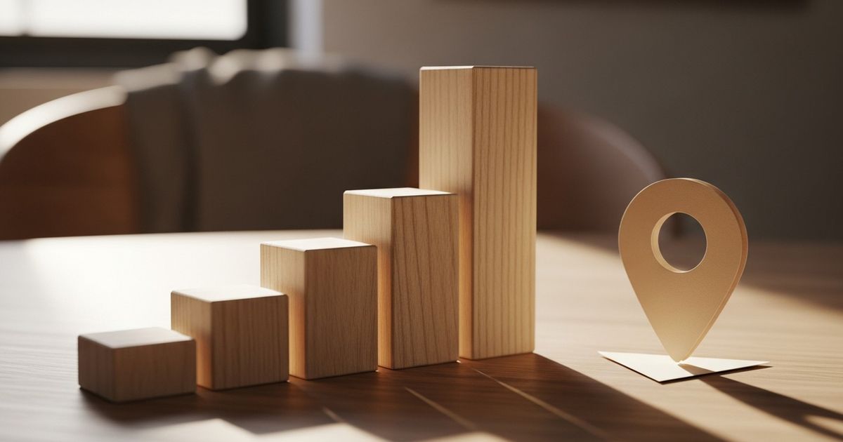 Wooden children's blocks stacked into ascending bars on a warm table, evoking growth and local focus for preschool SEO