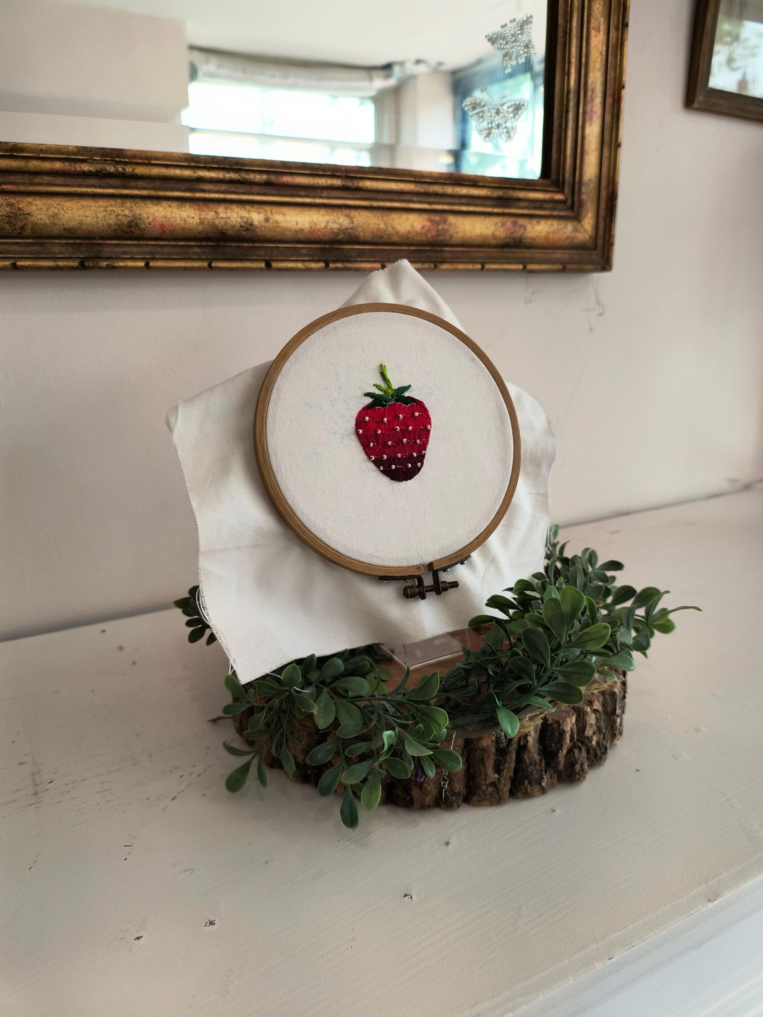Embroidery of a strawberry with beads as seeds.