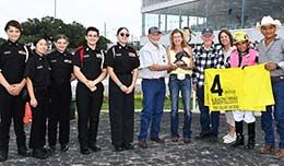 The winning connections of The Grand Ledgend accept the Q-Racing Video Sam Houston Distance trophy on Saturday.