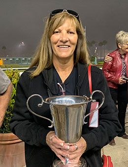 Winning owner Joyce Mowers accepts the Blane Schvaneveldt Handicap stakes trophy at Los Alamitos Race Course.