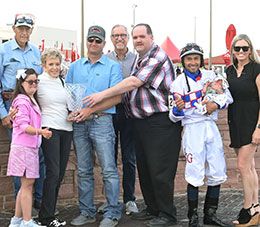 The winning connections of Cardiac Cowboy accept the Altoona Derby stakes trophy.
