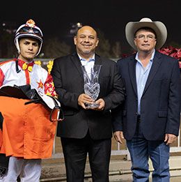 Los Alamitos Director of Marketing Orlando Gutierrez presents the Southern California Derby stakes trophy to trainer Monty Arrossa and jockey Armando Cervantes.