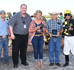 The winning connections of Margarets Cowboy accept the John Deere Prairie Meadows Juvenile Challenge stakes trophy.