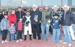 The winning connections of Rc Corona King accept the $90,000 Red Or Green Stakes [G2] trophy at Sunland Park on Sunday.