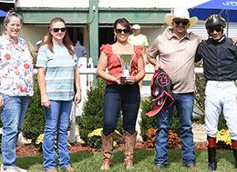 The winning connections of Captain Fancy accept the Henry Bolen Memorial Stakes trophy on Monday.